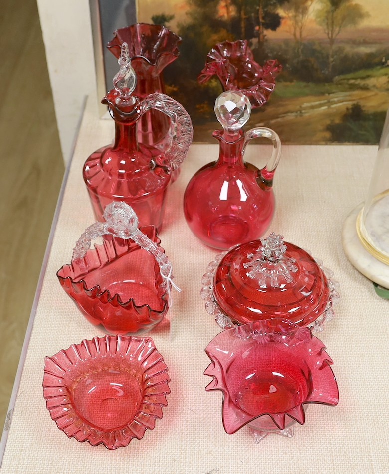A Victorian cranberry glass decanters, a powder bowl, basket, two vases and two bowls., Tallest decanter 30 cms high.